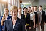 Portrait of businesswoman and business team standing in a row