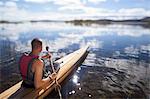 Young man canoeing, Norrbotten, Sweden