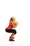 Young woman exercising with ball, studio shot