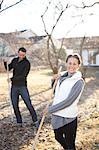 Couple raking leaves in garden, Stockholm, Sweden