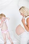 Pregnant mother with daughter, studio shot