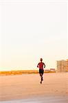 Woman running on beach at dusk