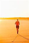 Woman running on beach at dusk