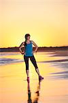 Woman standing on beach at sunset