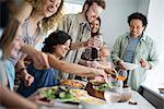 A family gathering for a meal. Adults and children around a table.