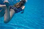 A child swimming under water in a swimming pool.