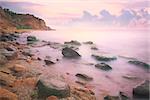 Colorful Sunset over the Sea and Rocky Coastline ,  flowing waves