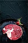 Meat. Raw meat beefsteak on  black with herbs