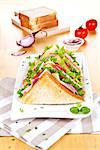 Tasty sandwiches with fresh vegetables on wooden table with tomatoes, onion, herbs and ketchup.