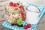 Healty breakfast with muesli, berries and milk. On wooden table
