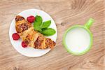 Milk and fresh croissant on wooden table