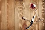 Red wine glass, corkscrew and wine cork on wooden table background with copy space
