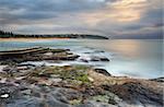 North view overlooking coast and rock pool at South Curl Curl. Australia.  Motion in water, clouds and railings