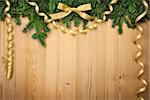 Christmas background with firtree, bow and ribbons on wood - horizontal