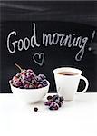 Coffee mug and fresh grape  on the table with blackboard on background