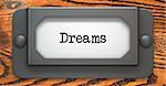 Dreams - Inscription on File Drawer Label on a Wooden Background.