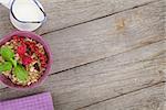 Healty breakfast with muesli, berries and milk. View from above on wooden table with copy space