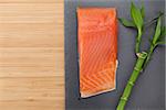 Fresh salmon fish on bamboo wooden table with copy space