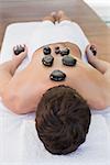 Close up of a young man receiving stone massage at spa center