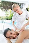 Portrait of an attractive young woman receiving back massage at spa center