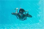 Young man wearing snorkel underwater while gesturing thumbs up