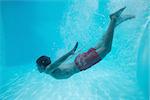 Full length side view of a young man swimming underwater