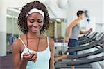 Pretty trainer looking at her stopwatch at the gym