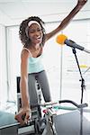 Spinning instructor motivating her class at the gym