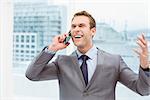 Smart young businessman using mobile phone in office