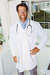 Portrait of confident smiling male doctor standing in medical office