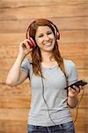 Happy enjoying woman listening with headphones to music in the city
