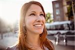 Smiling pretty redhead on a sunny day in the city