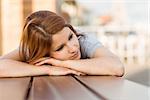 Day dreaming casual redhead lying on bench in the city