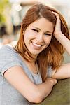 Pretty redhead smiling at camera in the city