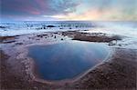 Steam rising from geothermal pools at sunrise in winter, Geysir, Haukardalur Valley, Iceland, Polar Regions