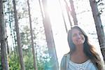 A woman enjoying a leisurely walk in a forest.