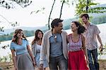 A group of people enjoying a leisurely walk by a lake.