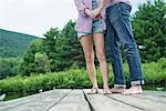 A couple on a wooden jetty by a lake.