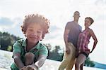 A family, parents and son spending time together by a lake in summer.