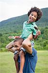 A father lifting his son up onto his shoulders.