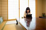 A woman sitting at a table with a laptop computer.