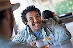 A  man sitting at a diner looking up and laughing.