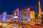 Neon lights on Las Vegas Strip at dusk with car headlights leaving streaks of light in front of Paris and Ballys, Las Vegas, Nevada, United States of America, North America