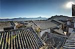 The roofs of Lijiang Old Town, UNESCO World Heritage Site, with Lion Hill silhouetted against a clear sky, Lijiang, Yunnan, China, Asia