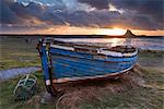 Decaying fishing boat on Holy Island at dawn, with Lindisfarne Castle beyond, Northumberland, England, United Kingdom, Europe