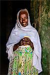 Friendly old woman standing in a door frame near Keren, Eritrea, Africa