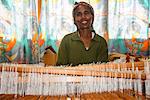 Friendly woman working on a hand weaving loom on a social project in the highlands of Eritrea, Africa