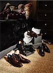 New, men's dress shoes and boxes on floor beside bed in bedroom, studio shot