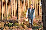 Young Woman Collecting Mushrooms in Scots Pine (Pinus sylvestris) Forest in Early Autumn, Bavaria, Germany