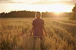 Boy standing on field at dusk